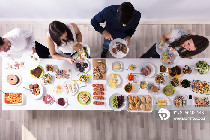 Group Of People Eating Food On Plate