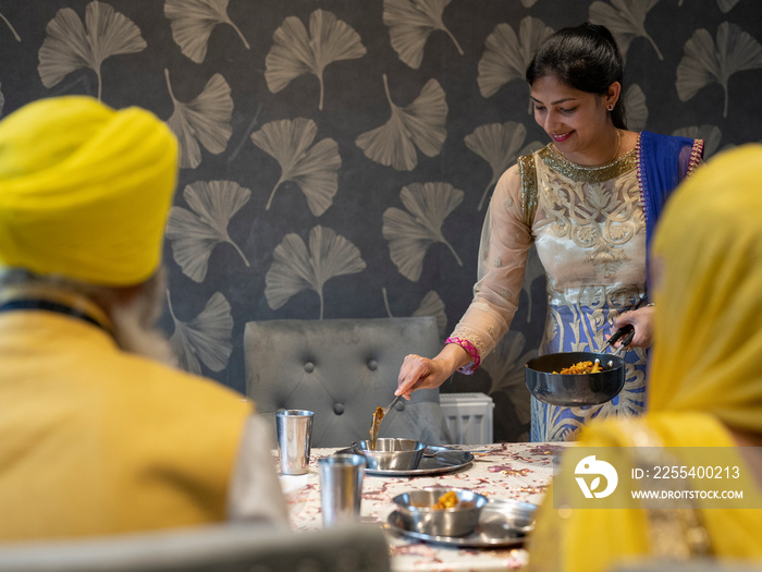 Family in traditional clothing eating meal at home