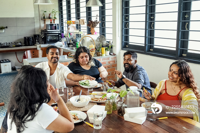 Group of friends sharing a meal together at home