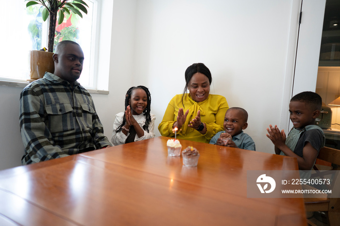 Family with children (2-3, 4-5, 6-7) celebrating at table