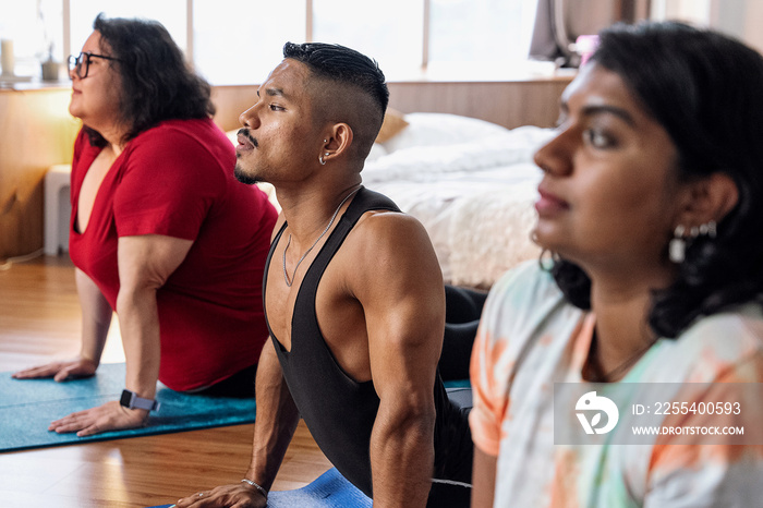 Group of friends meditating and doing yoga at home