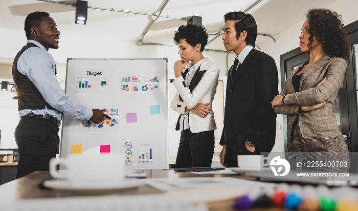 African american businessman and businesswoman Standing in the lead of a meeting with a presentation board as a graph document. The atmosphere is quite stressful in an office meeting.