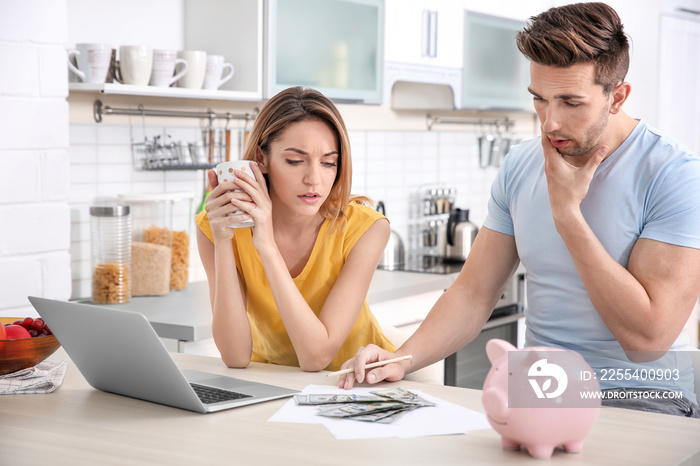 Young couple managing family budget at home