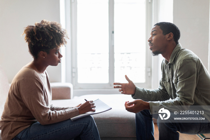 Black man sharing feelings and thoughts with therapist, side view