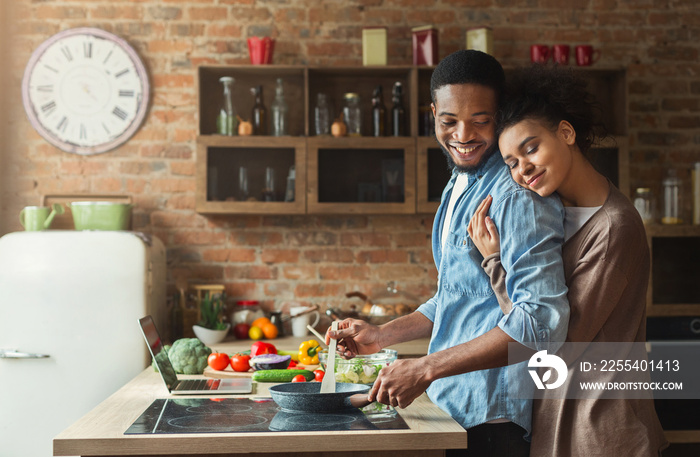 Loving black wife and husband preparing dinner in kitchen