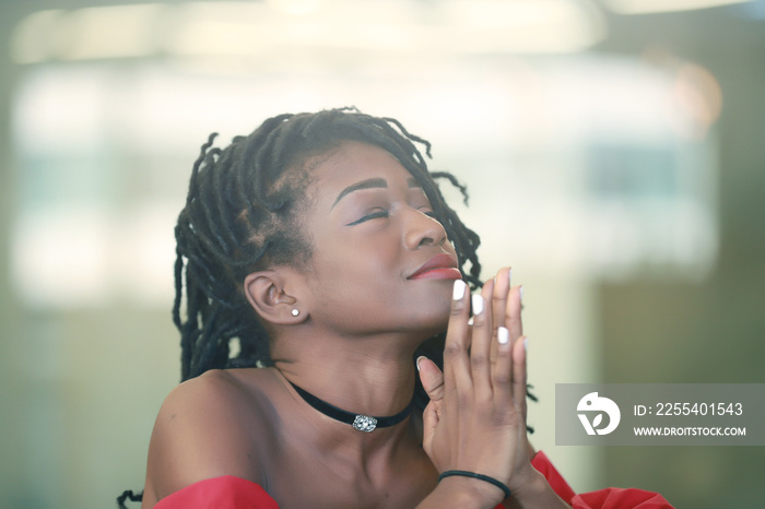 Pretty African girl folding hands during prayer