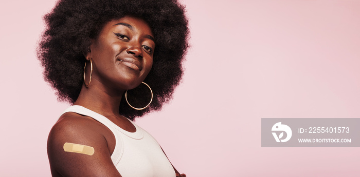 African woman with a vaccine bandage on her arm