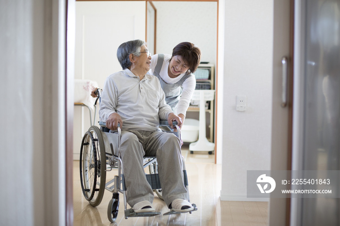 在宅介護、ヘルパーと車椅子の老人