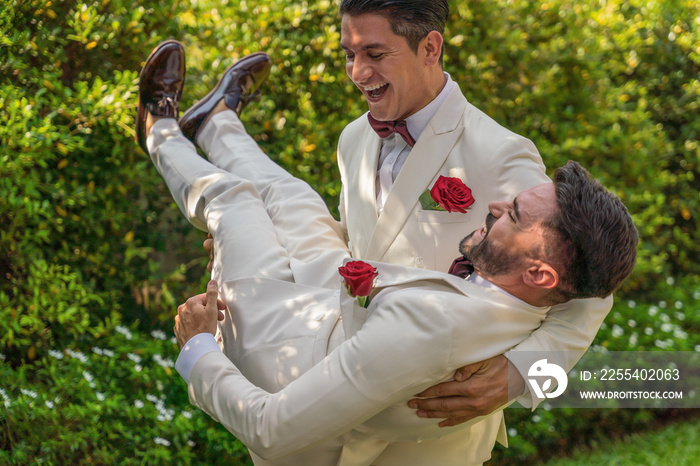 LGBTQ gay couple having fun together in garden in wedding ceremony