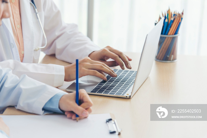 Close up hands of two women doctor medical lab discussing together healthcare teamwork. Two asian women hand doctors meeting write prescription medical clinic. Doctor discuss using laptop write note