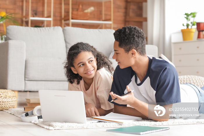 African-American brother and sister studying at home