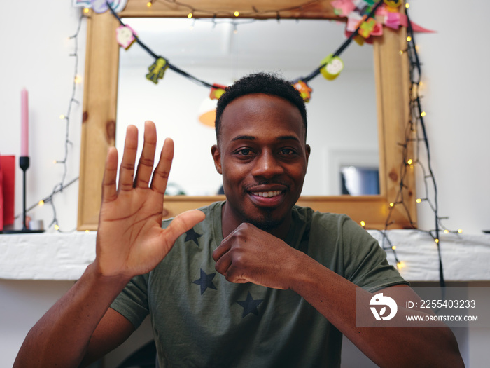 Portrait of man looking at camera and waving hand