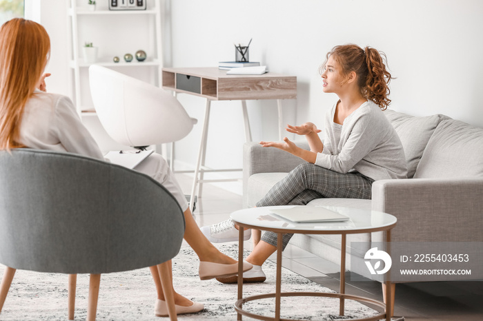 Psychologist working with teenage girl in office