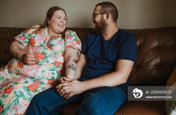 couple sitting on sofa talking and laughing