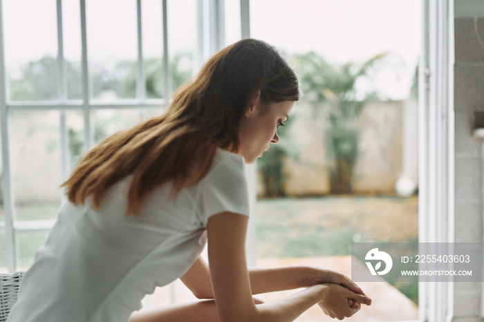 young woman looking out window