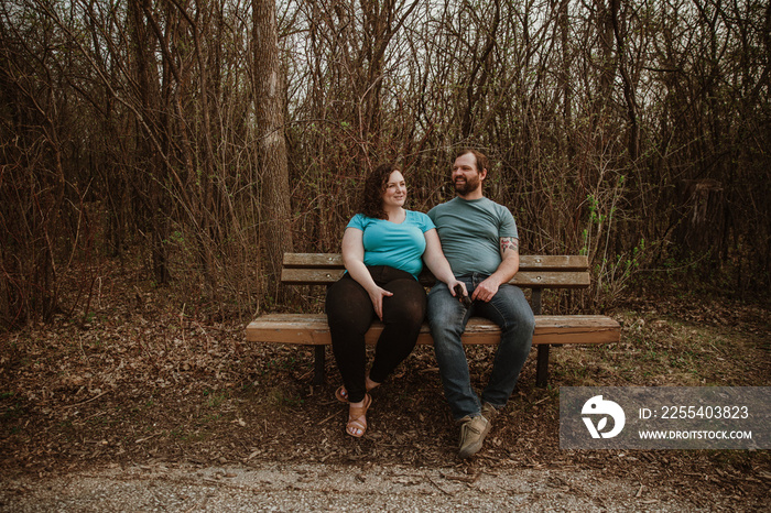 a couple sits on a bench talking