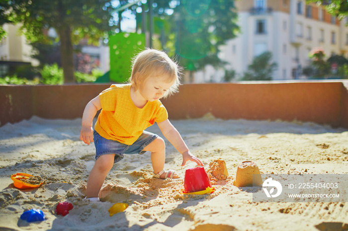 little girl having fun on playground in sandpit