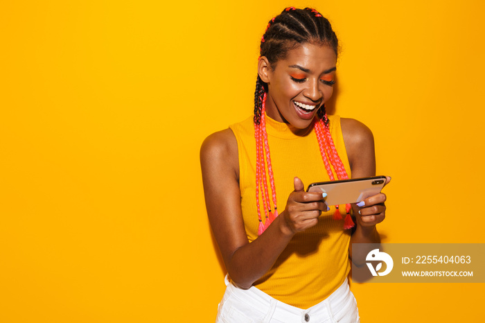 Image of beautiful african american woman with afro braids smiling and holding smartphone