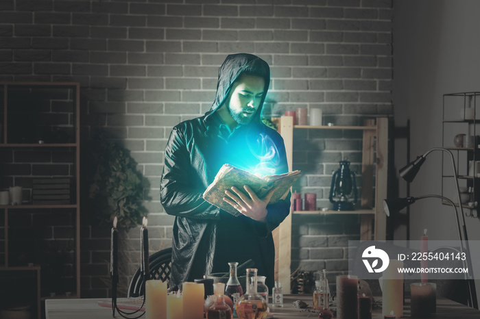 Male alchemist with spell book in laboratory