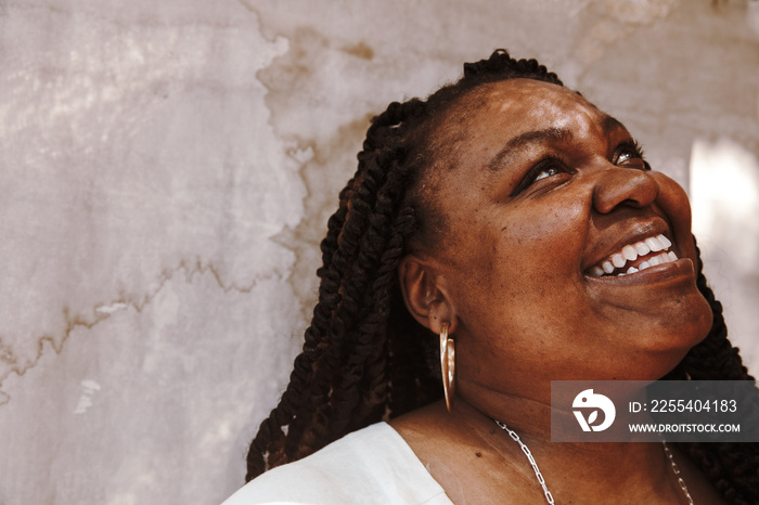 portrait of a plus size Afro Latinx Haitian American woman smiling and looking up