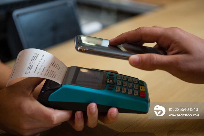 Cropped hand of customer making payment at bar