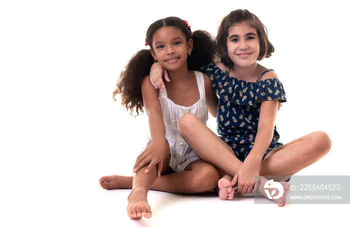 Two friendly small girls hugging  isolated on white