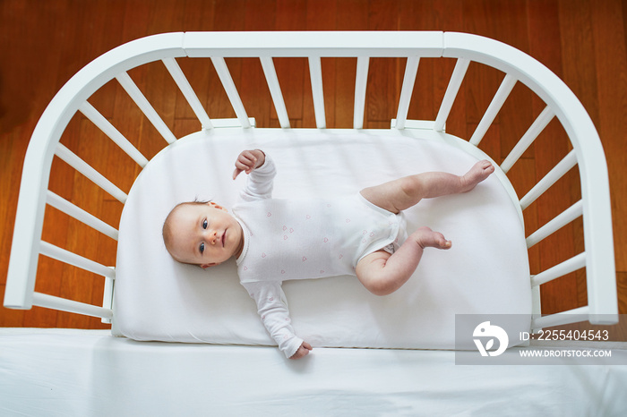 Baby girl in co-sleeper attached to parents’ bed