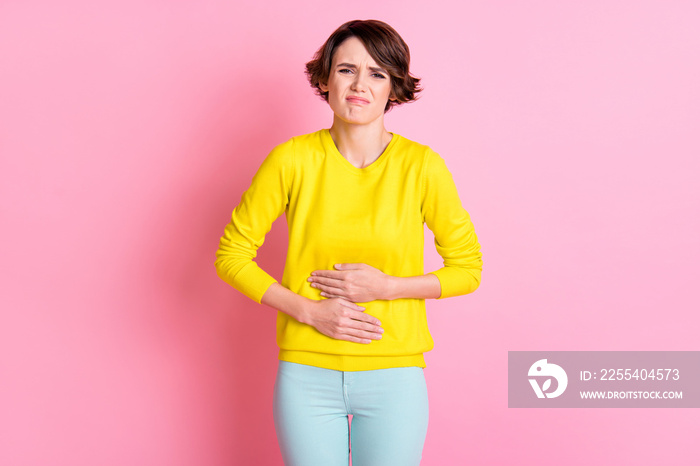 Photo of young unhappy sad stressed suffering girl hold hand on stomach pms syndrome isolated on pink color background