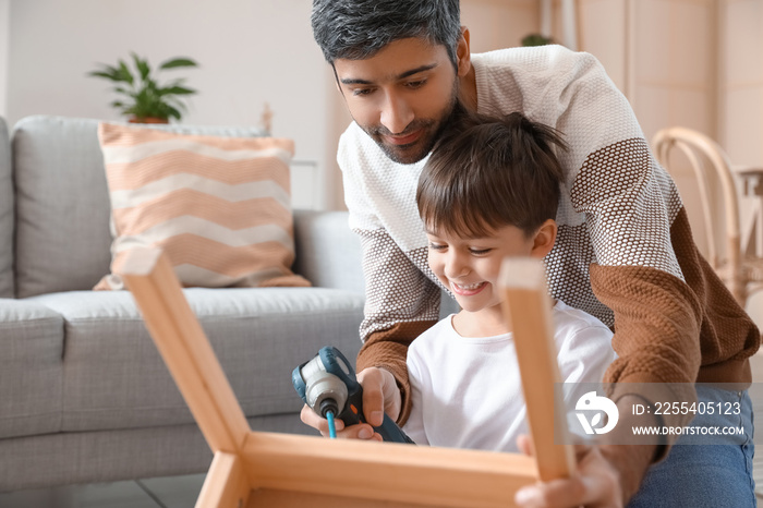 Father and little son fixing chair at home