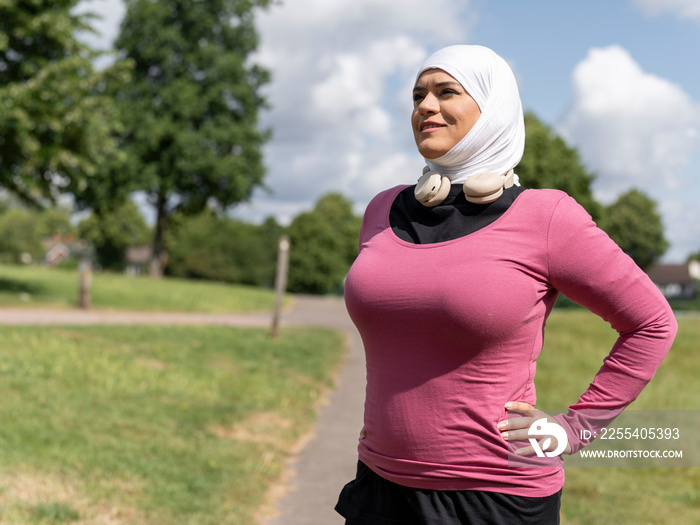 UK,Sutton,Woman in headscarf relaxing after workout in park