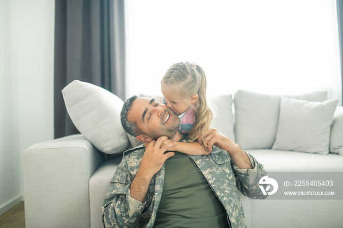 Loving daughter kissing her father being hero for the family