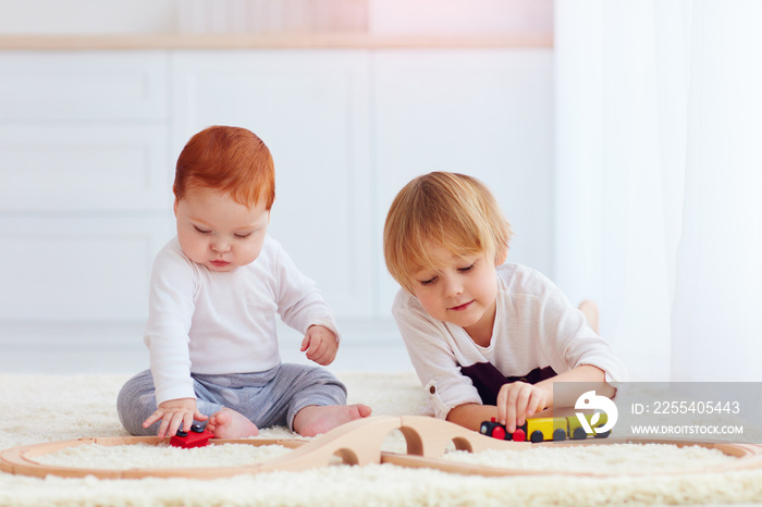 cute kids playing with toy railway road at home