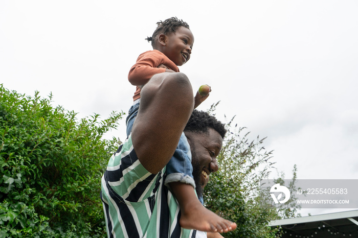 Father giving daughter (2-3) piggyback ride