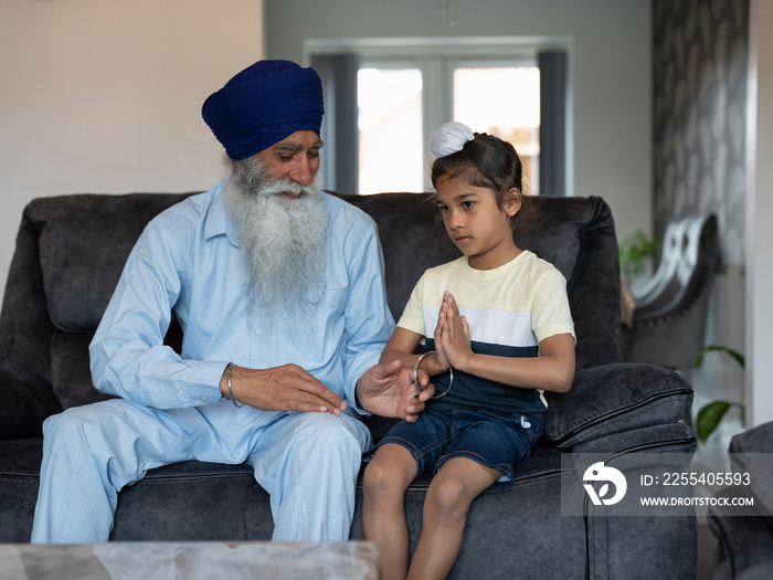 Grandfather teaching grandson (6-7) how to pray