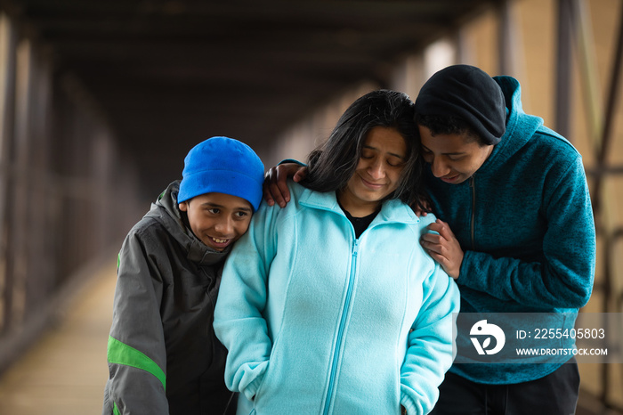 Hispanic Mother Walks With Sons On A Bridge