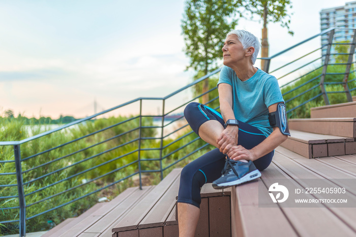 Senior Woman in pain while running in park, knee injury. Senior woman with an expression of severe pain in her leg. Athlete woman has calf crump, pain in leg during running