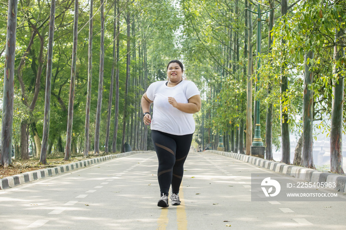 Obese woman jogging on the road