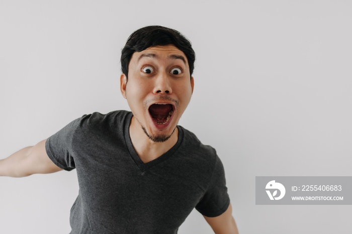 Funny surprised shocked asian man face for promotion isolated on background.