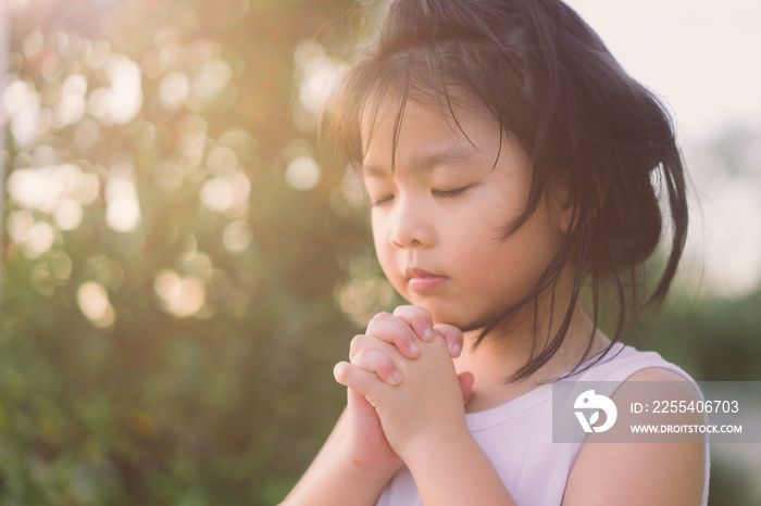 Little girl praying in the morning for a new day.Little asian girl hand praying for thank GOD,Hands folded in prayer concept for faith,spirituality and religion.