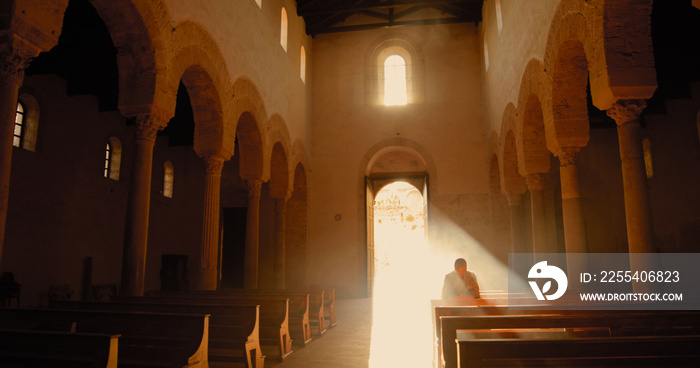 Vichingo o normanno con cotta di maglia in testa mentre prega in chiesa in ginocchio.