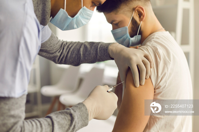 Doctor injecting patient with antiviral vaccine during mass vaccination campaign