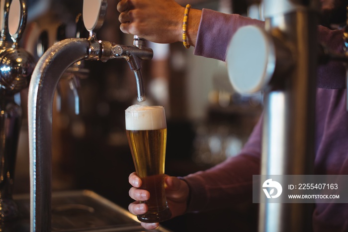 Close-up of bar tender filling beer from bar pump