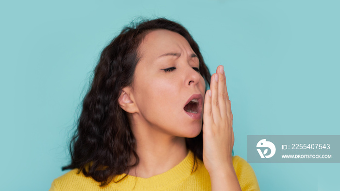 Health Care: Woman checking her breath with hand. Closeup portrait headshot sleepy young woman with wide open mouth Unrecognizable