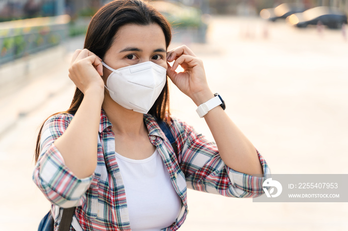 Asian woman wearing N95 mask to protect pollution PM2.5 and virus. COVID-19 Coronavirus and Air pollution pm2.5 concept.