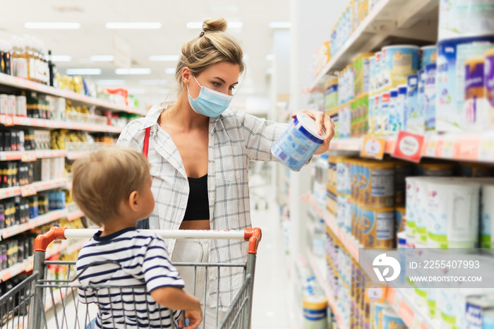 Mother and her little son in a supermarket during virus pandemic