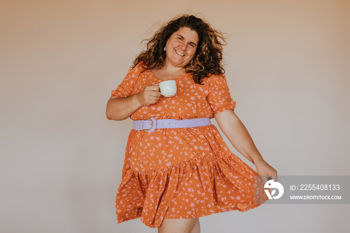 portrait of a plus size woman holding a coffee cup