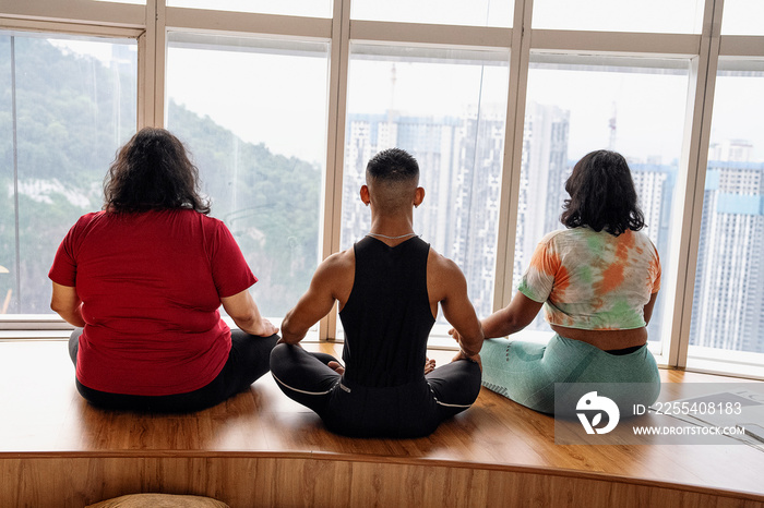 Group of friends meditating and doing yoga at home