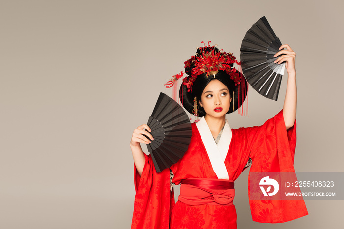 Japanese woman in oriental clothes holding fans isolated on grey