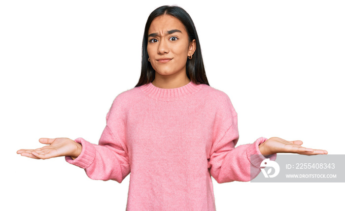 Young asian woman wearing casual winter sweater clueless and confused with open arms, no idea concept.