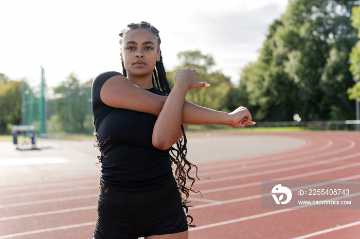 Female athlete stretching arms before training